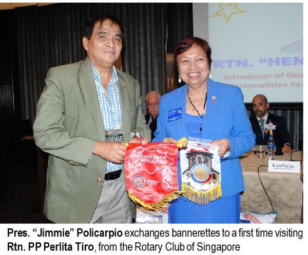 Pres. "Jimmie" Policarpio exchanges bannerettes to a first time visiting Rtn. PP Perlita Tiro, from the Rotary Club of Singapore.