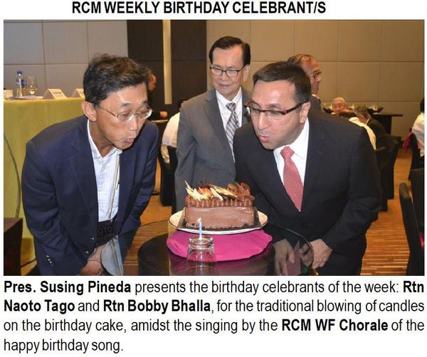 Pres. Susing Pineda presents the birthday celebrants of the week: Rtn Naoto Tago and Rtn Bobby Bhalla, for the traditional blowing of candles on the birthday cake, amidst the singing by the RCM WF Chorale of the happy birthday song.