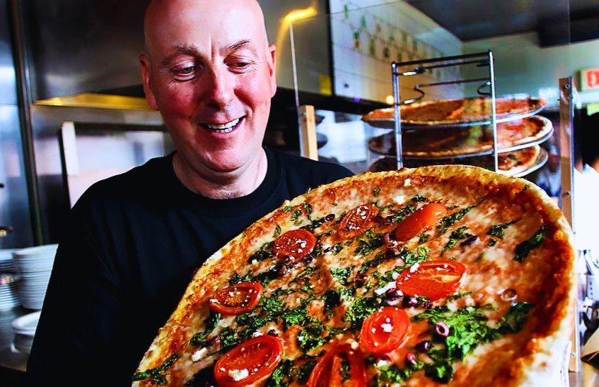 Dermot Doyne, owner Penguin Pizza, with one of their pizzas in 2018. – John Tlumacki / The Boston Globe, file