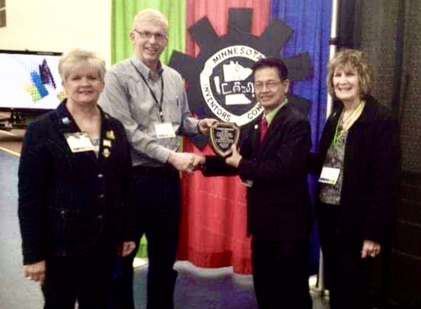 Rotarian John Simon receiving Outstanding International Inventors Award from the President of Minnesota Inventors Congress