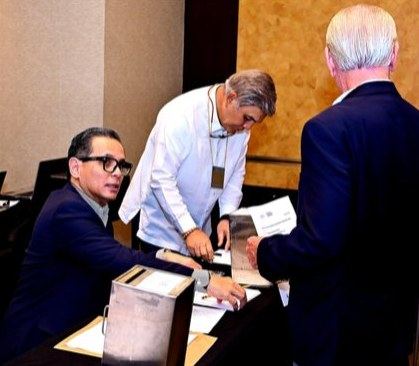 COMELEC Chairman and Immediate Past President Atty. Raoul Creencia assists Membership Chairman Fausto Preysler as he casts his ballot in the election of the Rotary Club of Manila's leaders for Rotary Year 2027–2028. The scene reflects the Committee's careful guidance and the active participation of members in choosing the Club's next leadership team.