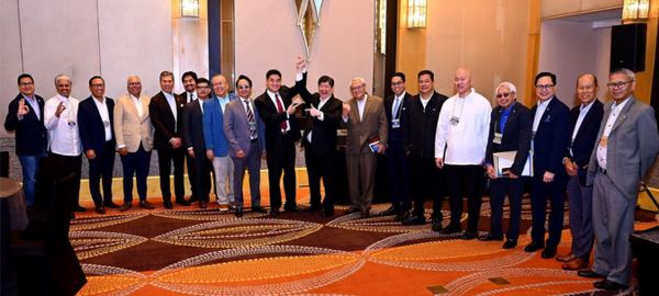A moment of celebration as President Reginald T. Yu raises the hand of incumbent Director Atty. Teddy Kalaw IV, newly elected President of the Rotary Club of Manila for Rotary Year 2027–2028, surrounded by jubilant members and officers who gathered to congratulate him and welcome the Club's next chapter of leadership.