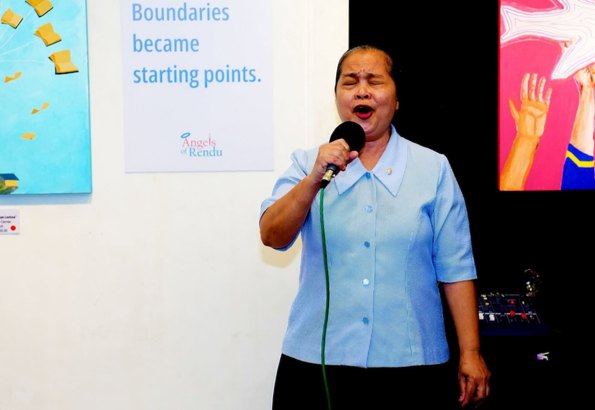 With eyes closed and heartfelt expression, Sr. Martha Gamolo, DC, Administrator of Hospicio de San Jose, shares a soulful song at the Beyond Limits celebration, adding a personal touch to an evening of art and fellowship.