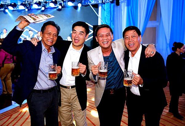 Four Rotarians, four mugs of amber beer, and a jubilant wave capture the spirited companionship of our Oktoberfest evening.