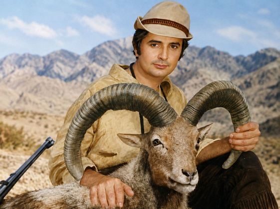 sDuring his years in Iran in 1973, Günter Matschuck embraced the rugged landscapes and traditions of the region, captured here with a majestic Urial sheep during a memorable hunting expedition.